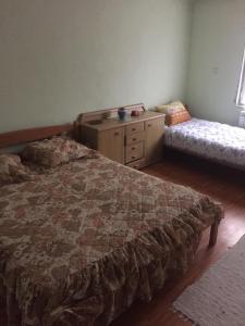 a bedroom with a bed and a dresser and a bench at Spacious and Charming House in Vozuća with Large Garden in Vozuća