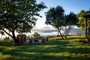 a park with a bench in the grass with mountains in the background at OPPIBERG GUEST HOUSE and SPA in Hartbeespoort