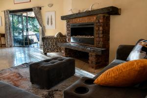 a living room with a couch and a fireplace at OPPIBERG GUEST HOUSE and SPA in Hartbeespoort