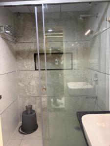 a glass shower in a bathroom with a sink at Senary's Nest INN in Kyātsandra +33 photos