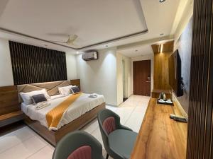 a bedroom with a bed and a table and chairs at Senary's Nest INN in Kyātsandra