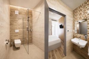 a bathroom with a shower and a toilet and a sink at Mizse Motel in Lajosmizse