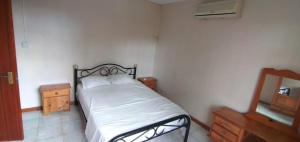 a small bedroom with a bed and a mirror at Family apartment with pool in Trou-aux-Biches, 80 m² in Trou aux Biches