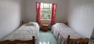 two beds in a room with a window at Family apartment with pool in Trou-aux-Biches, 80 m² in Trou aux Biches