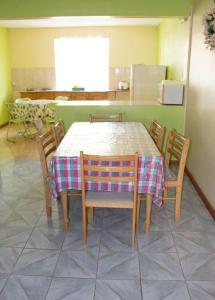 a table and chairs in a kitchen with a table and a refrigerator at Family apartment with pool in Trou-aux-Biches, 80 m² in Trou aux Biches