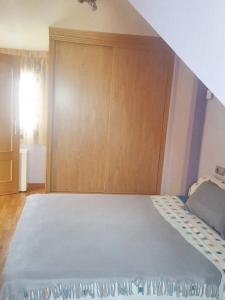 a bedroom with a large bed with a wooden door at Comfortable Apartment in Astorga + Terrace in Astorga