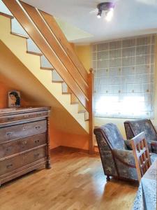 a living room with a staircase and a dresser and a chair at Comfortable Apartment in Astorga + Terrace in Astorga