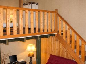 a wooden staircase in a living room with a bed at Studio confortable près de Beaumont-du-Périgord, 60 m², cheminée in Beaumont-du-Périgord