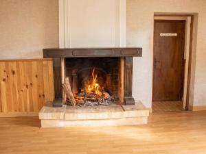 a fireplace with a fire in the middle of a room at Studio confortable près de Beaumont-du-Périgord, 60 m², cheminée in Beaumont-du-Périgord