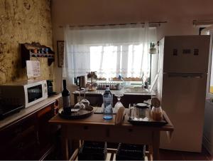 a kitchen with a table and a refrigerator at Charming House Santarém + Pool in Santarém