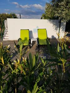 two green chairs sitting in front of a building at Charming House Santarém + Pool in Santarém