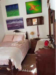 a bedroom with a bed with pink pillows and a dresser at Charming House Santarém + Pool in Santarém
