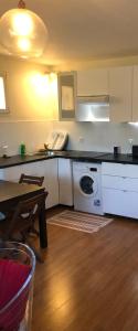 a kitchen with a washing machine and a table at Appartement cosy à Sannois de 110 m² avec jardin clôturé in Sannois +5 photos