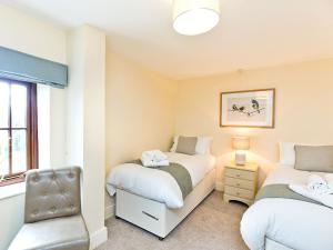 a bedroom with two beds and a chair at Ible Cottage - Qve in Hognaston