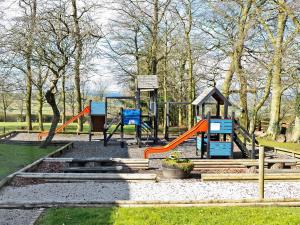 a playground with an orange slide in a park at Ible Cottage - Qve in Hognaston