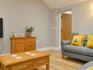 a living room with a couch and a coffee table at Bumble Cottage in Cockermouth
