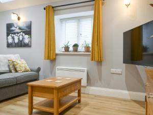 a living room with a couch and a table at Bumble Cottage in Cockermouth