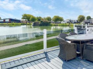 a deck with a table and chairs and a view of a river at Serenity At Lakeside - Uk51947 in Patrington