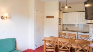 a kitchen and dining room with a table and chairs at Appartement accueillant Saint-Lary-Soulan 45 m² Piscine partagée in Saint-Lary-Soulan