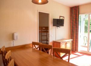 a dining room with a table and chairs and a television at Appartement accueillant Saint-Lary-Soulan 45 m² Piscine partagée in Saint-Lary-Soulan