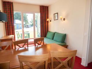 a living room with a table and chairs and a couch at Appartement accueillant Saint-Lary-Soulan 45 m² Piscine partagée in Saint-Lary-Soulan