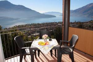 a table with a bowl of fruit on a balcony at Cozy apartment with lake view in Vercana +12 photos