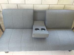 a gray couch with two bowls on top of it at Appartement charmant Morne-À-l'Eau in Morne-à-lʼEau