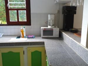 a kitchen with a microwave sitting on a counter at Appartement charmant Morne-À-l'Eau in Morne-à-lʼEau +6 photos