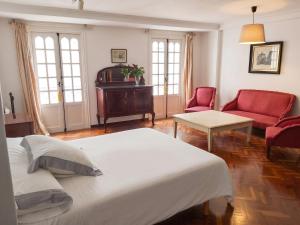 a bedroom with a bed and a piano and red chairs at Spacious house with terrace and balcony in A Coruña in A Coruña
