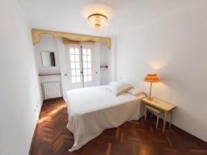 a white bedroom with a bed and a table at Spacious house with terrace and balcony in A Coruña in A Coruña