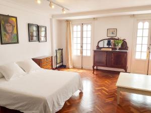a bedroom with a white bed and a table and windows at Spacious house with terrace and balcony in A Coruña in A Coruña