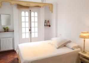a white bedroom with a bed and a window at Spacious house with terrace and balcony in A Coruña in A Coruña
