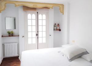 a white bedroom with a white bed and a window at Spacious house with terrace and balcony in A Coruña in A Coruña +26 photos