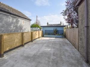 a driveway with a fence and a blue garage at Struan in Kilconquhar