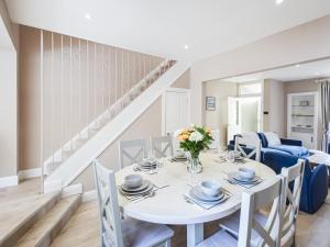 a white dining room with a white table and chairs at Struan in Kilconquhar