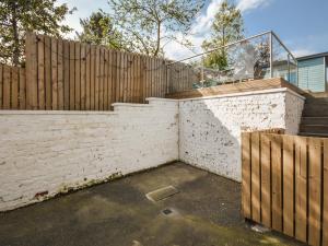 a retaining wall with a wooden fence and a staircase at Struan in Kilconquhar +16 photos