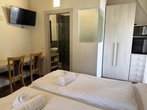 a bedroom with two white towels on a bed at Sugadoi in Predazzo