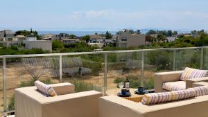 a balcony with couches and a view of a city at CasaMare Lagonisi Athens Riviera Luxury modern villas apartment's in Lagonissi