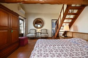 a bedroom with a bed and a staircase and chairs at Casa do Moinho in Ulgueira +23 photos