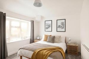 a bedroom with a bed with a gold blanket on it at Willow Cottage in Pateley Bridge