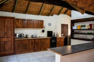 a kitchen with wooden cabinets and a counter top at OPPIBERG GUEST HOUSE and SPA in Hartbeespoort