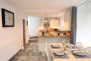 a kitchen and dining room with a table and a clock at Willow Cottage in Pateley Bridge