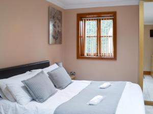 a bedroom with a white bed with two phones on it at George's Gaff - E4432 in Ingoldmells