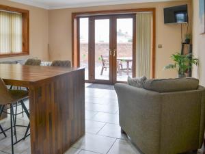 a living room with a wooden table and chairs at George's Gaff - E4432 in Ingoldmells +5 photos