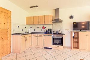 a kitchen with wooden cabinets and a stove top oven at Waldlust in Abtsgmünd