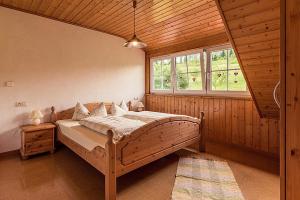 a bedroom with a large bed in a wooden room at Waldlust in Abtsgmünd