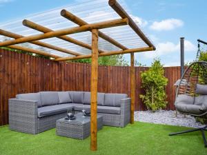 a pergola in a backyard with two couches and a table at Laurel Pod - Uk47203 in Westhead +2 photos