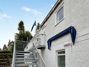 a building with a blue cover on the side of it at Heathergems Apartment in Pitlochry