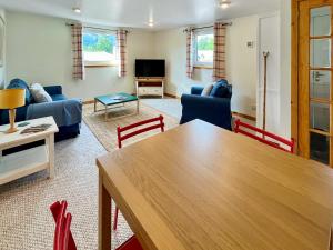a living room with a table and chairs at Heathergems Apartment in Pitlochry