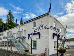 a white building with a sign that reads congratulations at Heathergems Apartment in Pitlochry